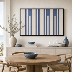 Blue and white geometric hand-woven wool tapestry beautifully staged in a bright dining room over a wooden sideboard.