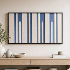 The Blue Cadence hand-woven wool tapestry styled above a minimalist light wood console table with decorative ceramics.