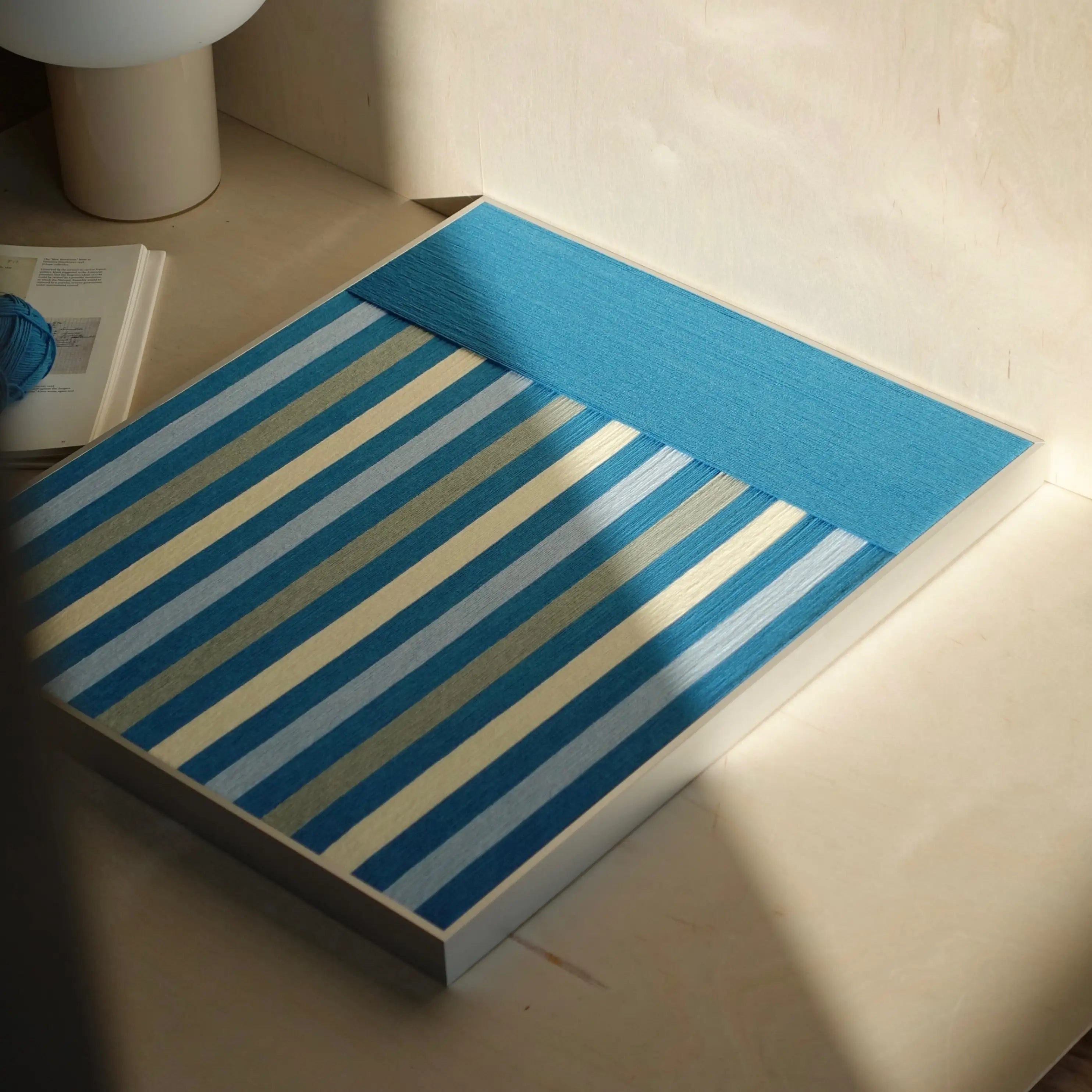 Blue Night yarn wall art flat lay view showing square form and uniform blue stripe weave, emphasizing balanced color transitions and stitch uniformity