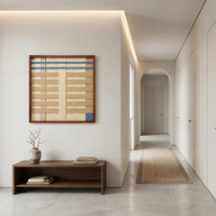 Square textured wool art creating a warm focal point in a modern minimalist hallway, hanging above a low wooden bench.