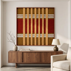 Framed Gilded Coronation textile wall art styled above a comfortable beige armchair in a sunlit modern living room setting.