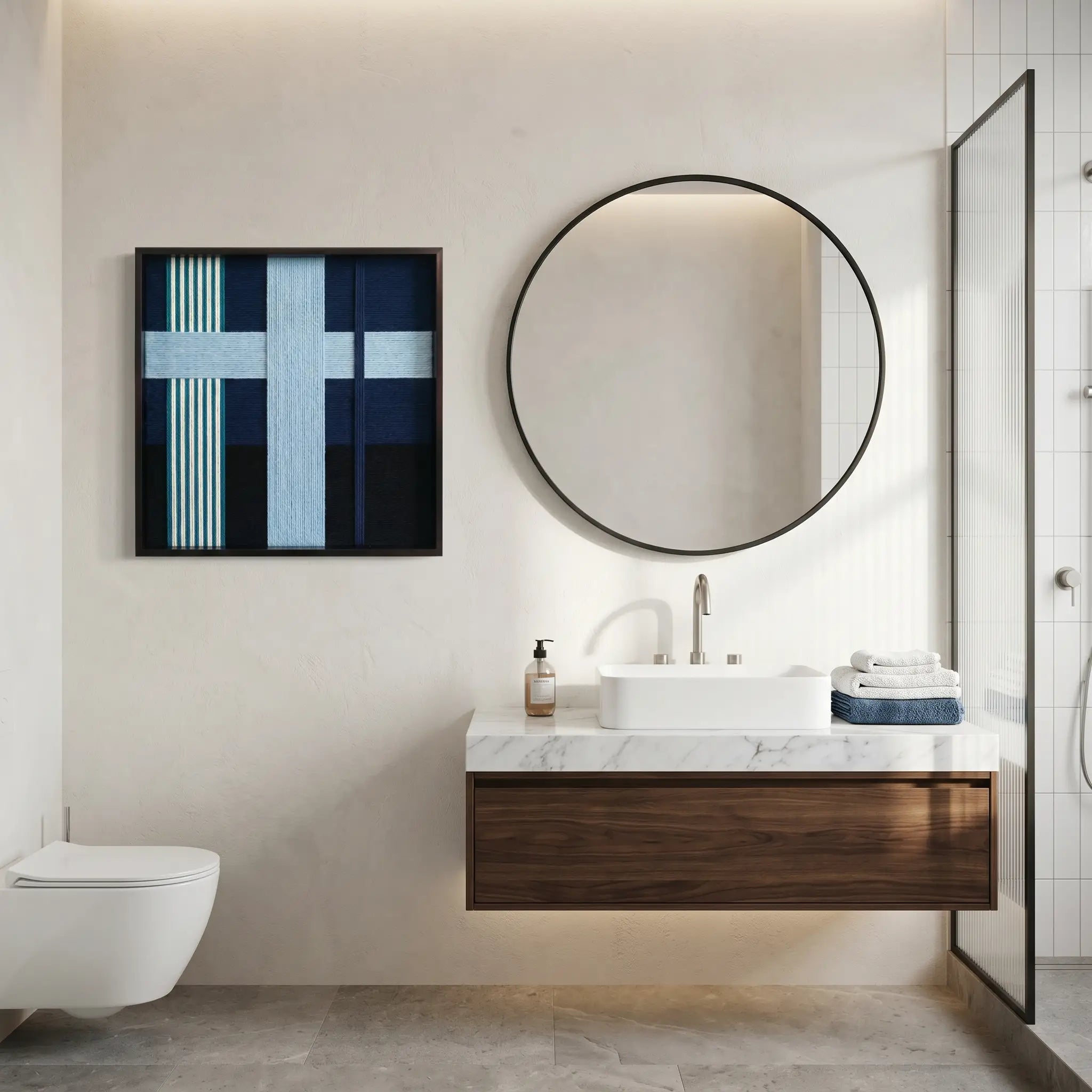 Framed textured wool wall art displayed in a luxury bathroom above a floating walnut vanity and large circular mirror.