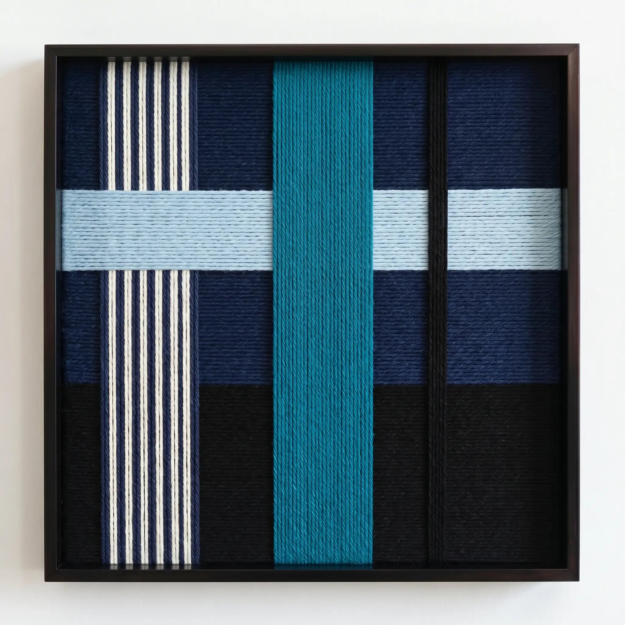 Professional studio shot of the Glacial Stationeries hand-woven fiber art showcasing a central teal-blue vertical block and geometric patterns.