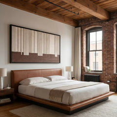 Beautiful framed hand-woven textile wall art styled elegantly above a wooden bed in an industrial loft bedroom with exposed brick walls.