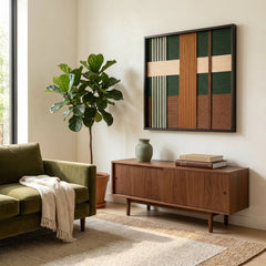 Framed forest green and terracotta textured wool art styled in a bright lounge area with a velvet green sofa and neutral rug.