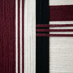 Detailed macro shot of the Midnight Opera wool tapestry highlighting the rich burgundy and black hand-wrapped yarn textures.