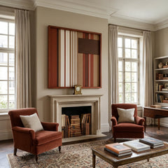 Striking square hand-woven wool tapestry positioned perfectly above a classic fireplace mantel in a bright living room featuring two rust-colored armchairs.
