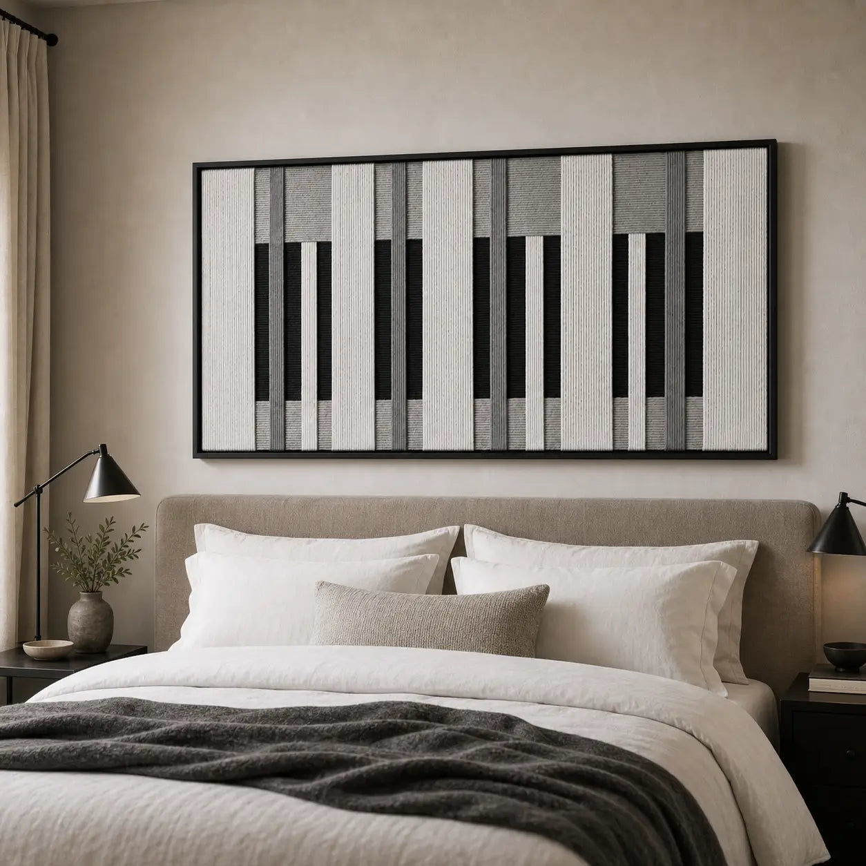 A beautiful framed piano-key inspired hand-woven wool tapestry displayed gracefully above a styled bed in a cozy, neutral bedroom.