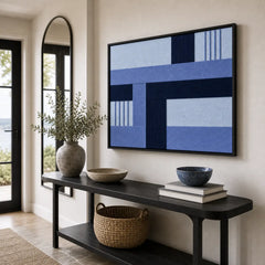 Striking Nordic Tide framed wall art styled in a bright entryway next to a mirror, hanging above a sleek black console table.