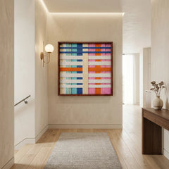 Colorful textured fiber wall art hanging above a dark wood credenza in an elegant dining space with natural light.