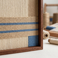 Macro close-up of the wooden frame corner and blue wool stripes, highlighting the high-quality hand-woven textile craftsmanship and dense texture.