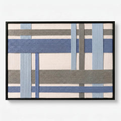 Frontal studio shot of the Slate Harbor hand-woven wool wall art featuring blue and grey geometric patterns in a black frame.