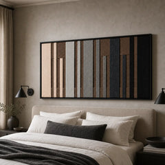 A beautiful framed hand-woven wool tapestry displayed gracefully above a styled bed with dark accents in a cozy bedroom.