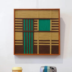 Vast Horizon hand-woven yarn wall art displayed on a shelf with minimal décor, highlighting its ocean-blue panel and earth-tone stripe contrast