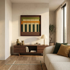 Textured wool wall hanging in a dark wood frame styled above a contemporary low-profile cabinet, blending organic materials with minimalist home decor.