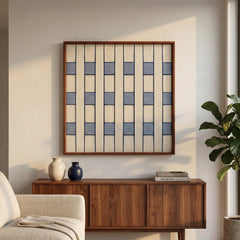Square framed fiber wall art hanging above a dark wood sideboard in a sunlit modern living room.