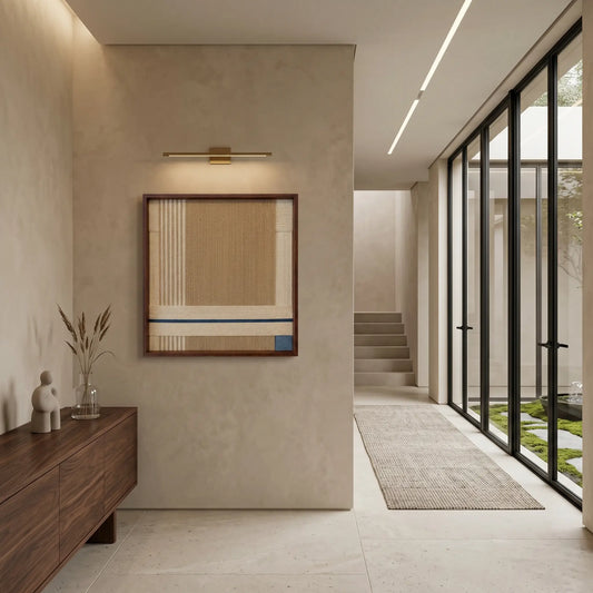 Framed wool wall art displayed in a modern architectural hallway with high ceilings and natural light.