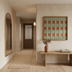Square woven wool tapestry styled in a minimalist entryway above a simple wooden console table.