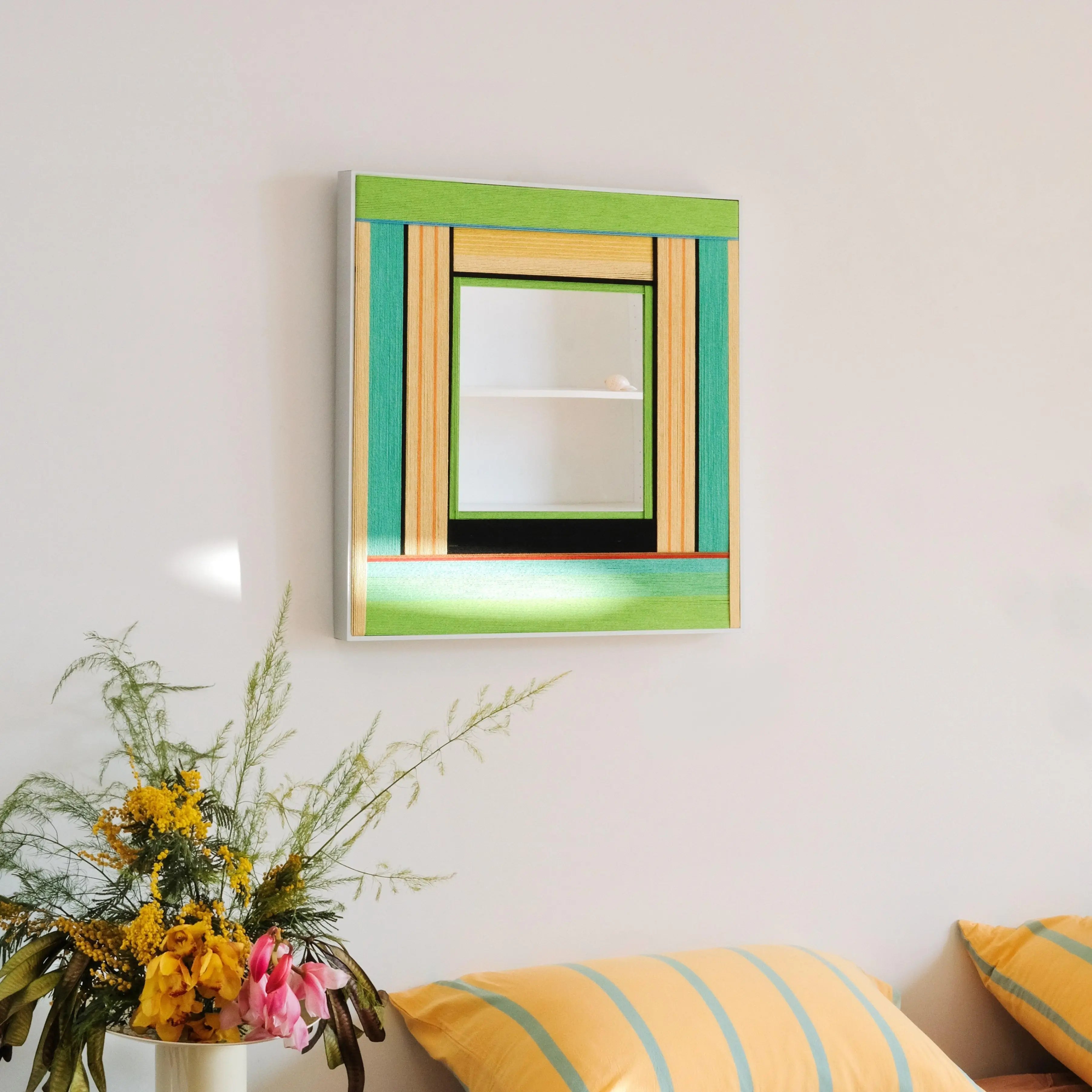 Hand‑held close-up of Breathing Like Fresh Grass showing its compact square proportions and precise green-and-wood stripe alignment.
