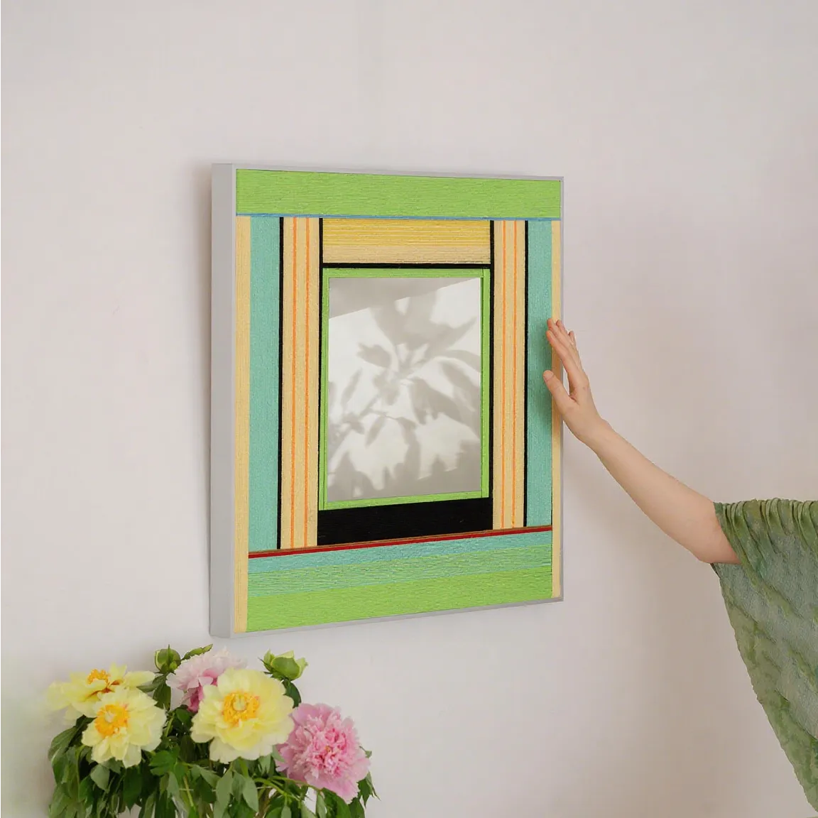 Breathing Like Fresh Grass mirror wall art mounted above a side table in a living room, emphasizing its soothing green palette and modern organic style.
