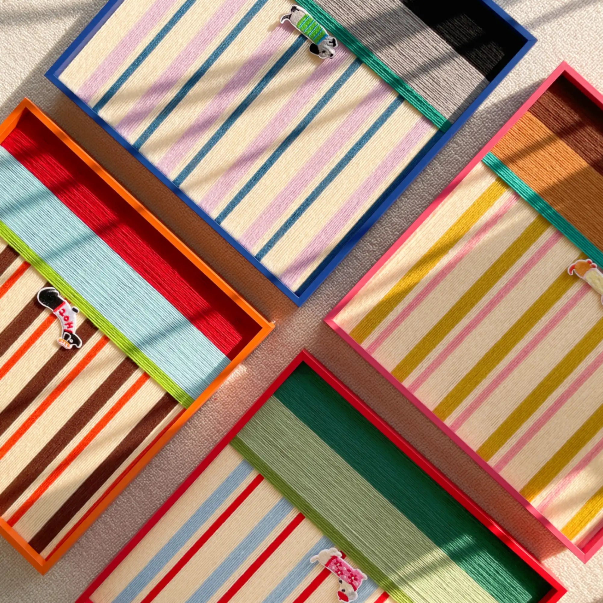 A creative layout showing multiple hand-woven wool wall art pieces from the collection, highlighting various colorful striped patterns and textures.