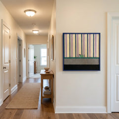 Large square Cerulean Stripe Pup Frolic textile wall art featuring pastel stripes and a small dog detail, hanging in a bright modern hallway with hardwood floors.