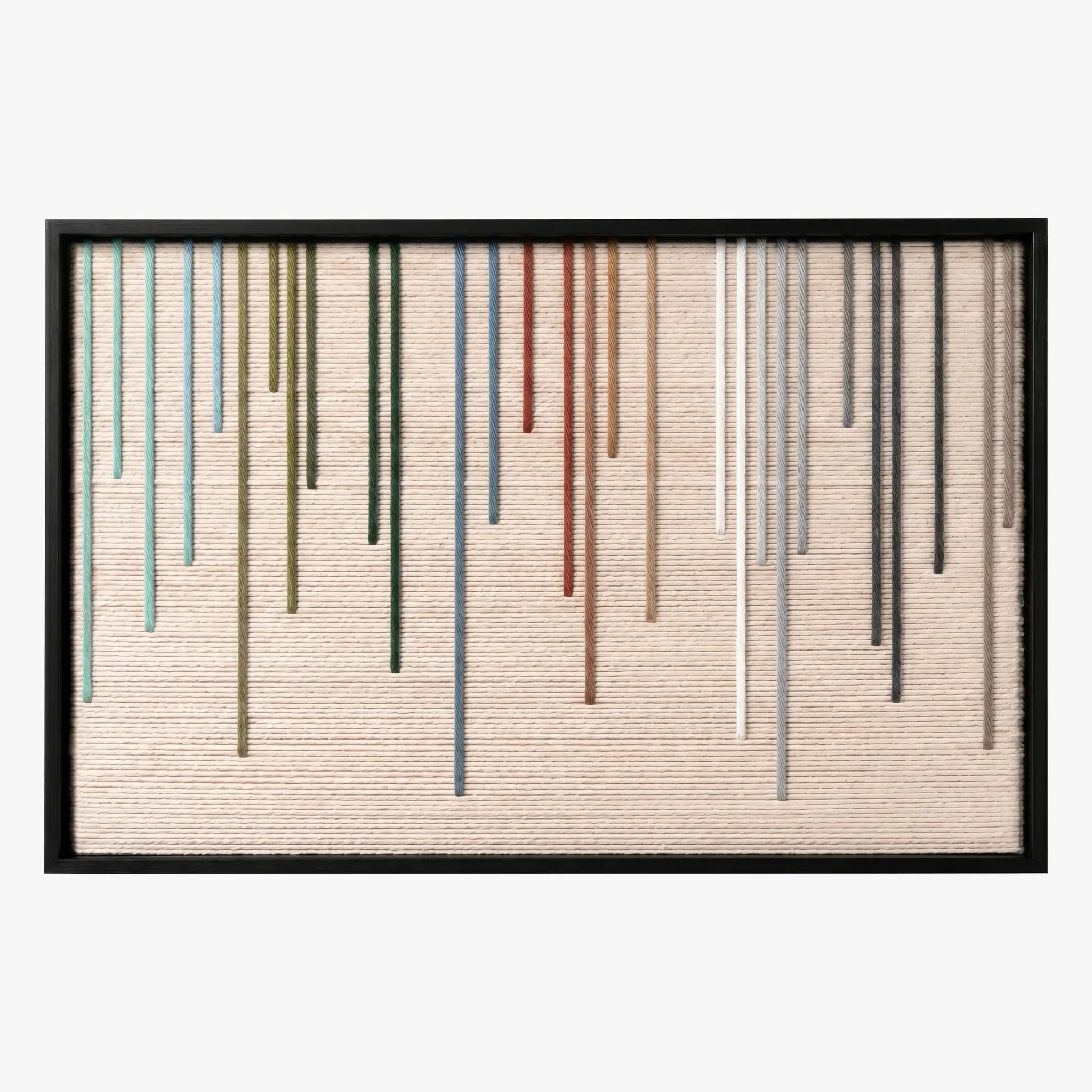 Frontal studio shot of the Chromatic Rain hand-woven wool wall art featuring colorful vertical dripping yarn stripes on a beige background in a black frame.