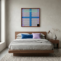 Framed geometric hand-woven wool wall art styled in a calm bedroom as a striking focal point above a modern bed with matching blue accent pillows.