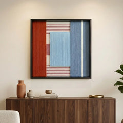 A single framed piece from the Cold Fire textile art collection hanging elegantly above a dark wood credenza adorned with ceramic vases.