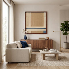 A large-scale textured wool wall art piece centered in a spacious, sunlit living room featuring natural wood furniture and minimalist aesthetic.