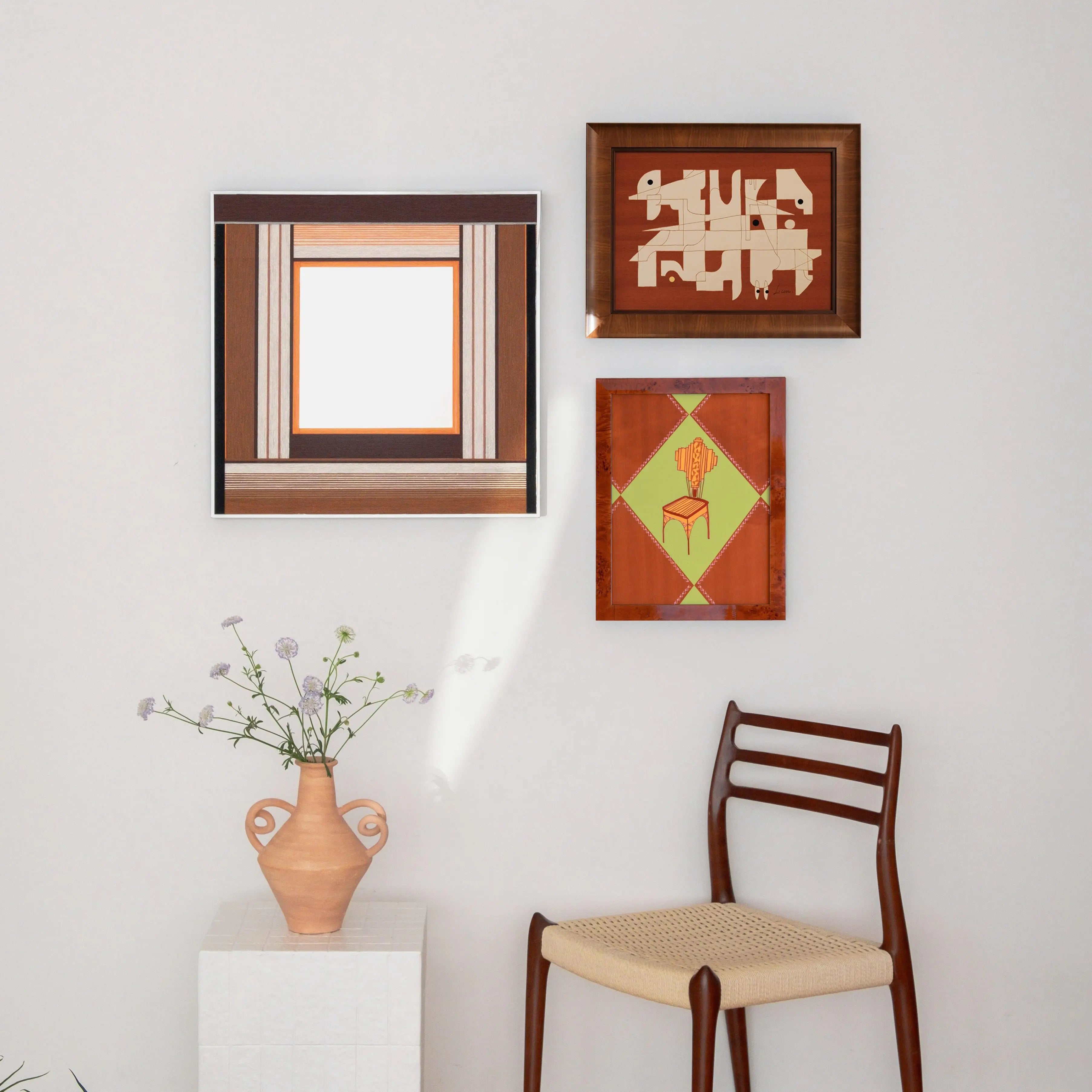 A cohesive gallery wall display featuring the Bread & Coffee woven mirror alongside smaller textured art pieces in a warm, earthy interior setting.
