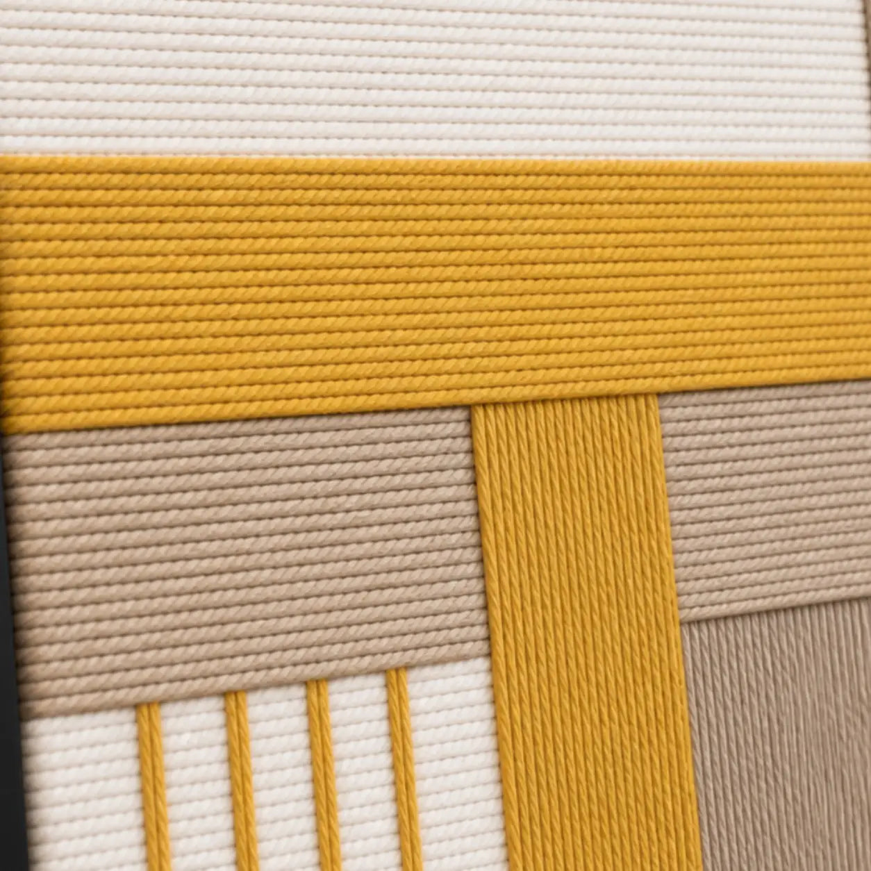 Detailed macro close-up of the Golden Interval hand-woven wool tapestry highlighting thick mustard yellow and beige textured yarn.