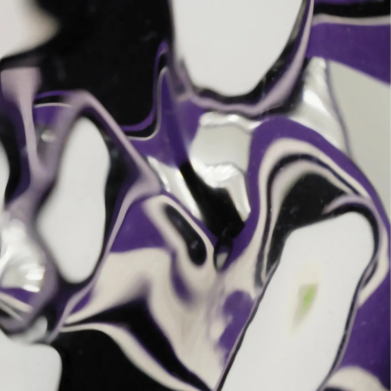Macro view of the reflective panel in HOUTIAN mirror art capturing distorted mirror reflections against purple and black stripe backdrop.
