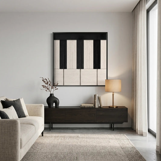 A framed Little Black Piano hand-woven wool tapestry hanging above a modern wooden sideboard in a bright, contemporary living room setting.