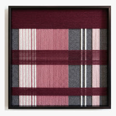 Frontal studio shot of the Merlot Veil square hand-woven textile wall art featuring burgundy, pink, and grey geometric block patterns in a black frame.