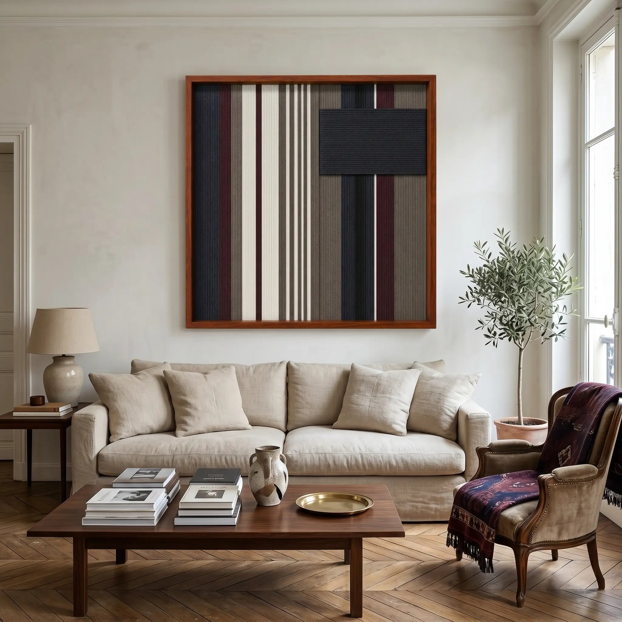 Framed Midnight Fjord textile wall art displayed in a warm living room, hanging above a comfortable beige sofa decorated with a plaid throw blanket.