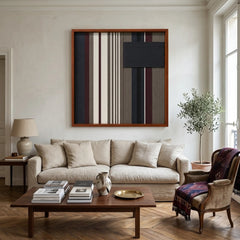 Framed Midnight Fjord textile wall art displayed in a warm living room, hanging above a comfortable beige sofa decorated with a plaid throw blanket.