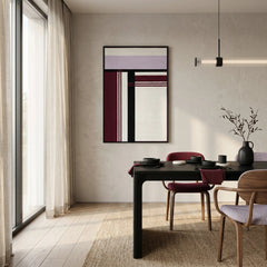 Hand-woven wool tapestry in deep red and purple tones styled in a contemporary dining room with neutral walls and a black table.