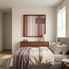 Beautiful square framed hand-woven textile wall art styled elegantly above a bed featuring a matching plum purple throw blanket in a serene, neutral bedroom.