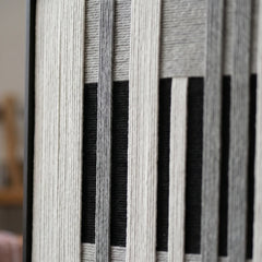 Detailed macro close-up of the Monochrome Tempo hand-woven wool tapestry highlighting the thick black, white, and grey textured yarn.