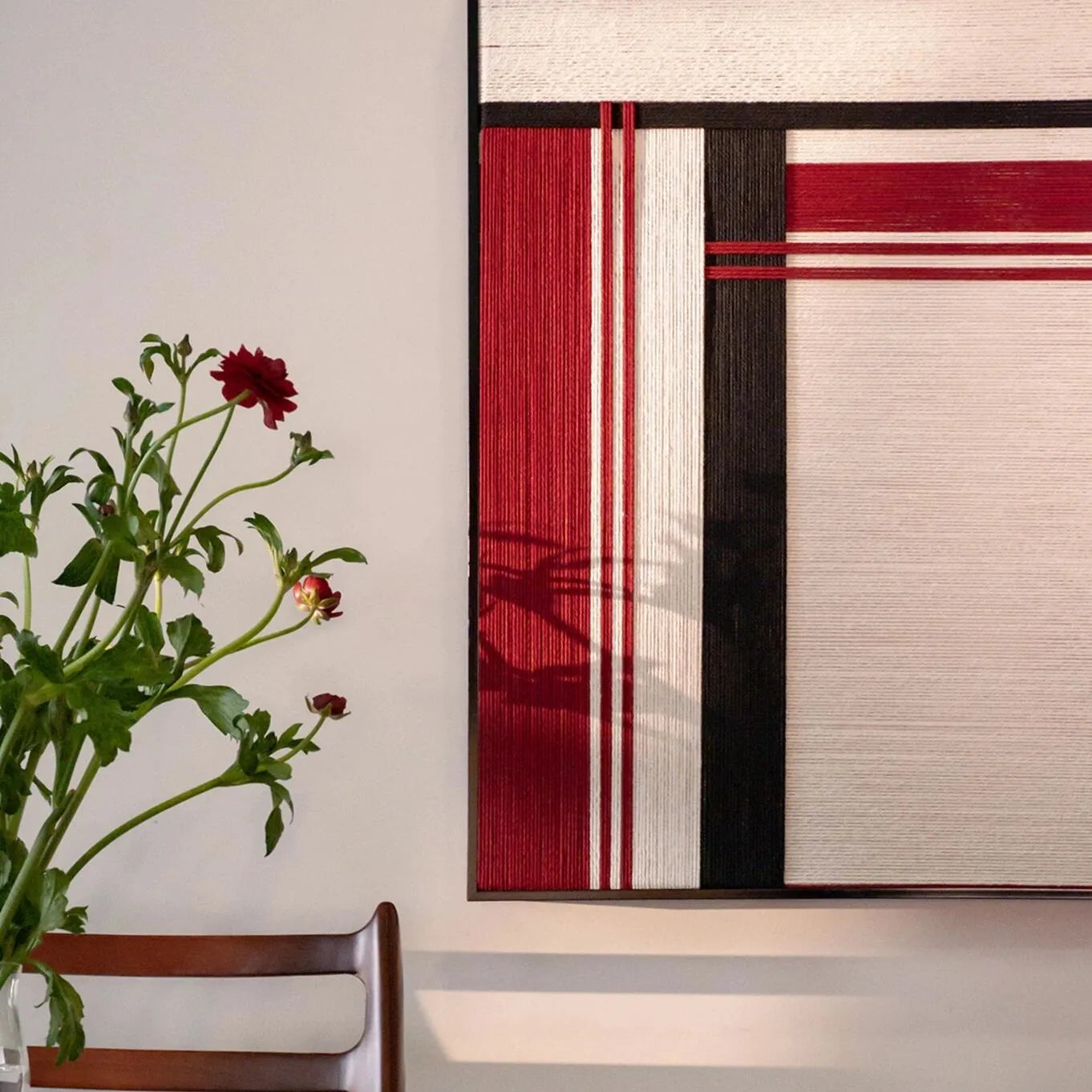 Angled view of “Napoli” yarn wall art showing precise geometric weave of red and black stripe panels and seamless stitching
