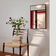“Napoli” yarn wall art reflected in a mirror to showcase the full red and black stripe design and sleek frame
