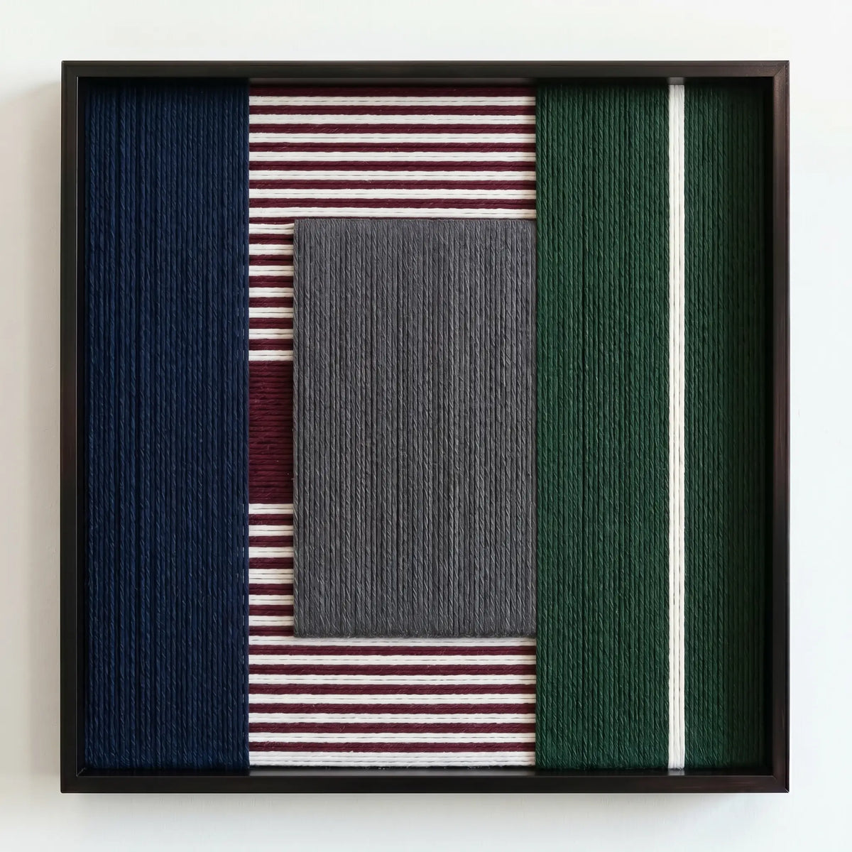 Professional studio shot of the hand-wrapped yarn wall art with a textured grey center and burgundy side panels.