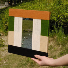 Alternate hand-held angle of Pastoral Elegance yarn art highlighting precise stitch detail on green and beige panels
