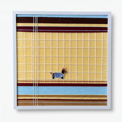 Professional studio shot of the Pawsy Puppy hand-woven wool wall art in a light silver frame against a white background.