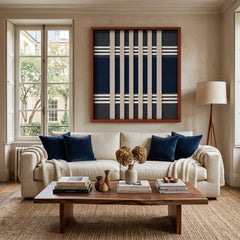 Framed Polar Meridian textile wall art displayed in a bright living room, hanging above a comfortable beige sofa and wooden coffee table.