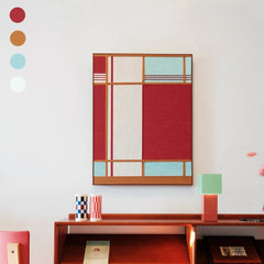 Red House hand-woven wool yarn wall art with a bold red central panel flanked by turquoise and natural wool stripe borders in a natural wood frame, displayed above a wooden desk with a mint cube lamp and decorative vase.
