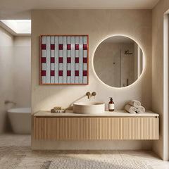Sophisticated framed hand-woven wool tapestry styled in a bright luxury bathroom above a floating wood vanity and a backlit circular mirror.