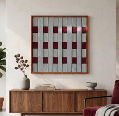 Square grey and ruby red textured fiber art displayed as a focal point in a modern living space above a walnut wood sideboard.