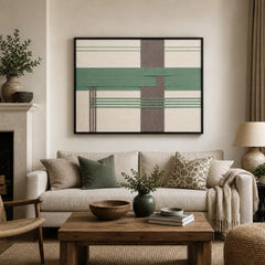 Framed Sage Crossing hand-woven wall art displayed above a cozy beige sofa in a modern, neutral-toned living room setting.